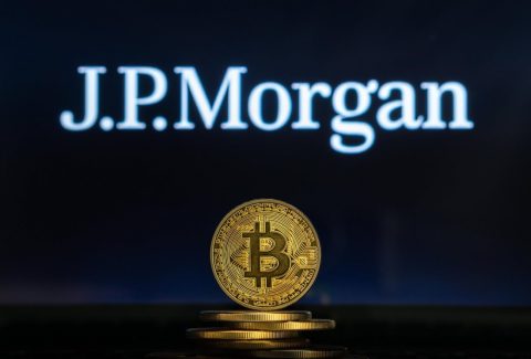 Bitcoin on a stack of coins with JPMorgan logo on a laptop screen. Cryptocurrency and blockchain adoption getting mainstream. Slovenia - 02 24 2019