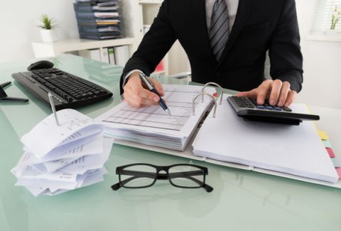 54191004 - close-up of businessman calculating tax in office